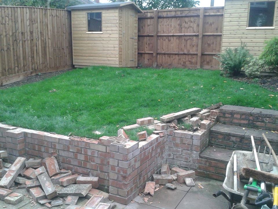 Rainbow sandstone patio with oak sleeper walls and rope balustrade in Aylesbury garden