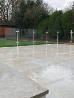 Full-width steps and modern balustrade framing a large porcelain patio