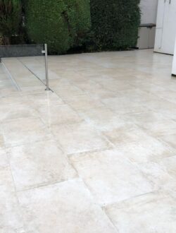 Smooth porcelain paving with glass fencing and slot drain detail