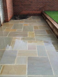 Straight-on view of central steps between two turf sections with Raj Green paving