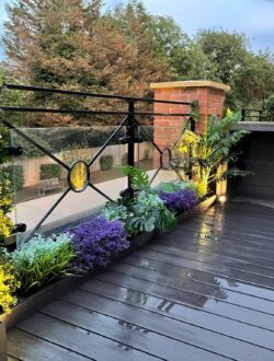 Contemporary garden dining space on grey composite decking with LED lighting