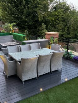 Deck lighting and artificial planting alongside glass railing